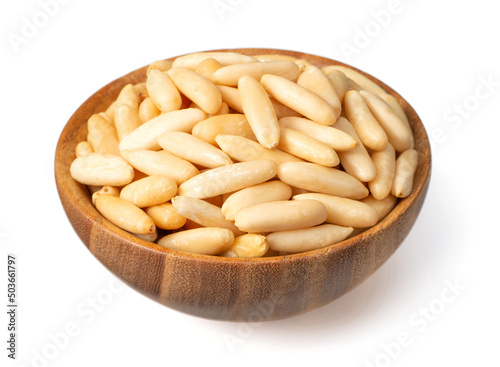 Roasted pine nuts in the wooden bowl. isolated on white background.