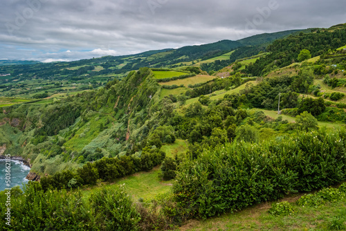 Green bushes at Tio Domingos viewpoint for panorama cliffs with typical landscape fields and mountains of São Miguel Island, Azores PORTUGAL © Liliana