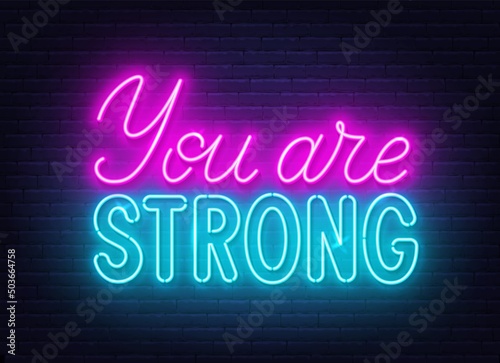 You are strong neon sign on brick wall background.