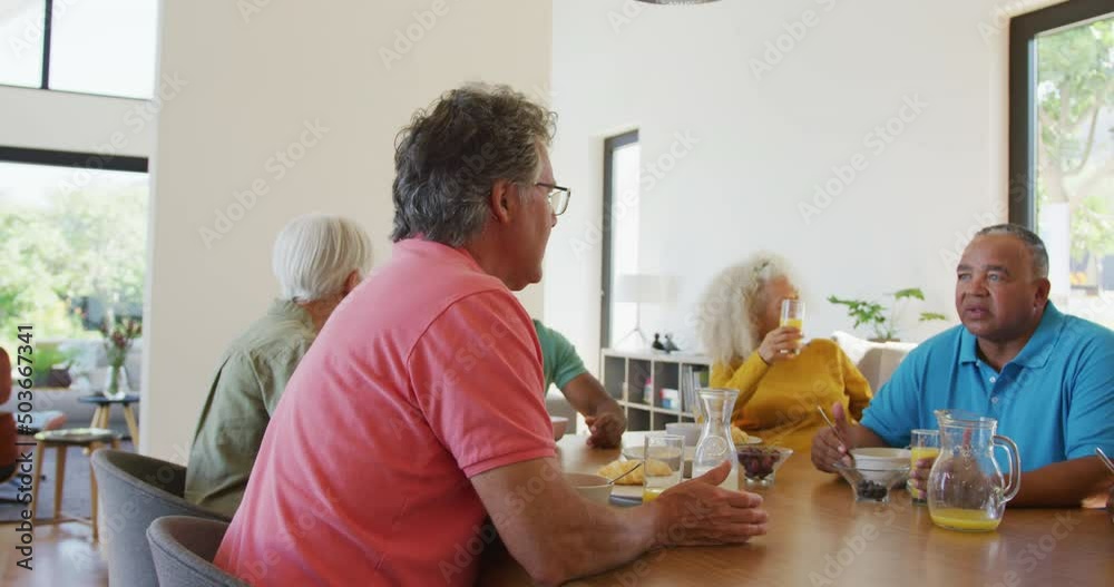 Happy senior diverse people having breakfast at retirement home