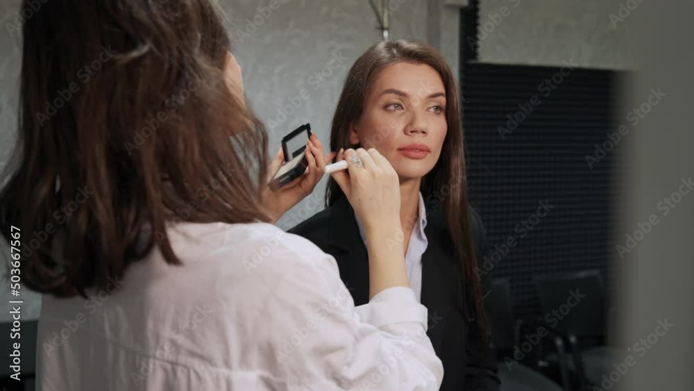 Skin toning process, female makeup artist make a makes up a TV presenter before live broadcast of news, preparing for media event, makeup artist at work. Skin toning process, female makeup artist make a makes up a TV presenter before live broadcast of news, preparing for media event, makeup artist at work.