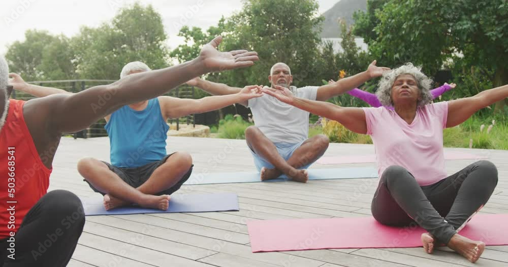 Happy senior diverse people practicing yoga in garden at retirement home Happy senior diverse people practicing yoga in garden at retirement home