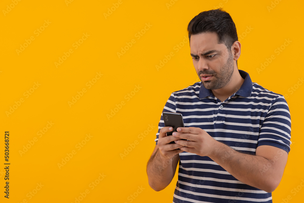 Young man with surprised facial expression while using Smartphone Young man with surprised facial expression while using Smartphone