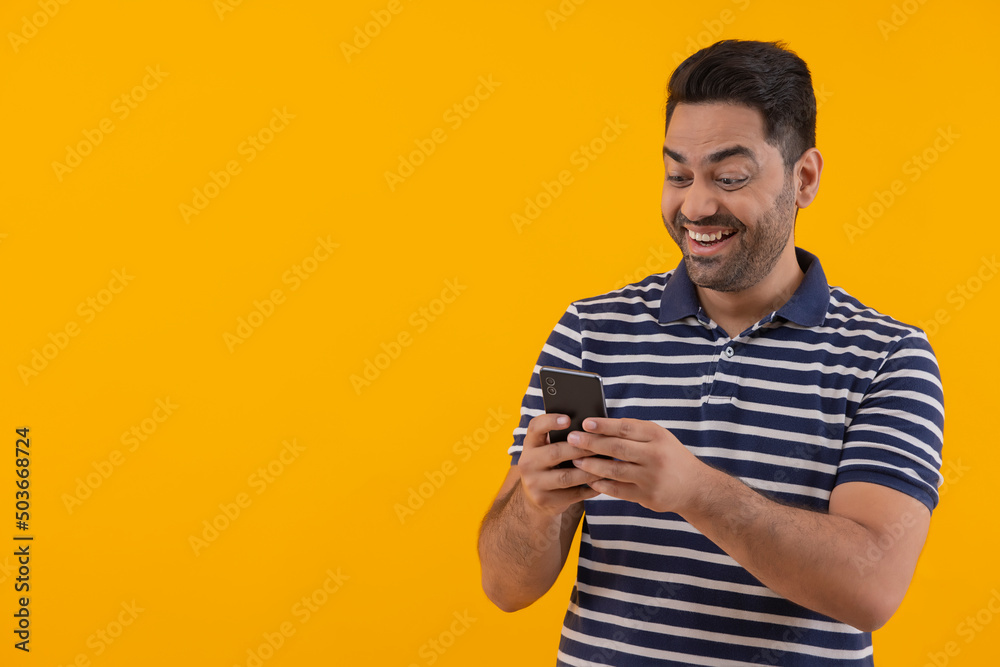 Portrait of happy young man having fun while using Smartphone Portrait of happy young man having fun while using Smartphone