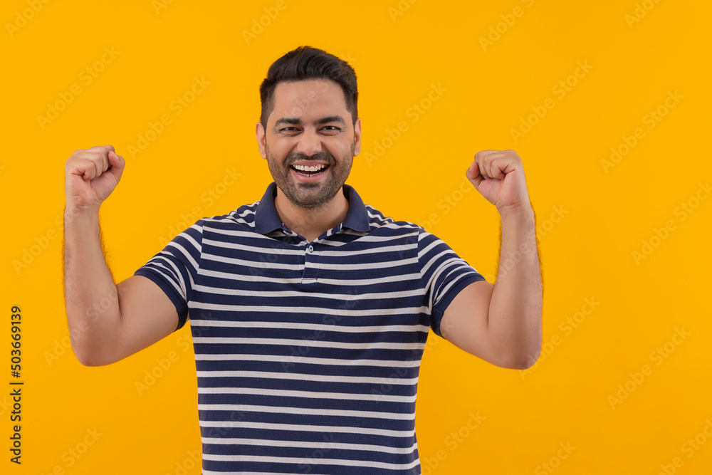 Happy young man cheering with raising his fists Happy young man cheering with raising his fists