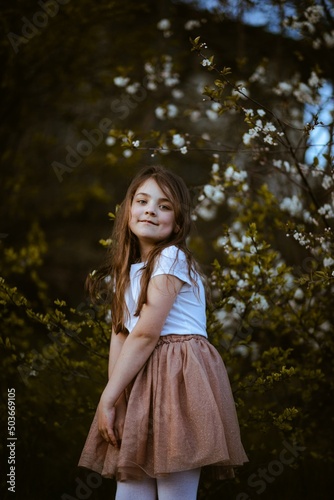 Radosna dziewczynka przy drzewach jabłoni 