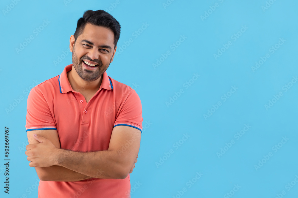 Portrait of a smiling young man looking at camera with hands folded