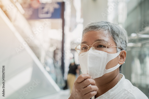 Senior Asian eyeglasses in New normal life wear medical facemask protection virus corona pandemic outbreak COVID-19 disease while feeling safe from the coronavirus outbreak, soft focus