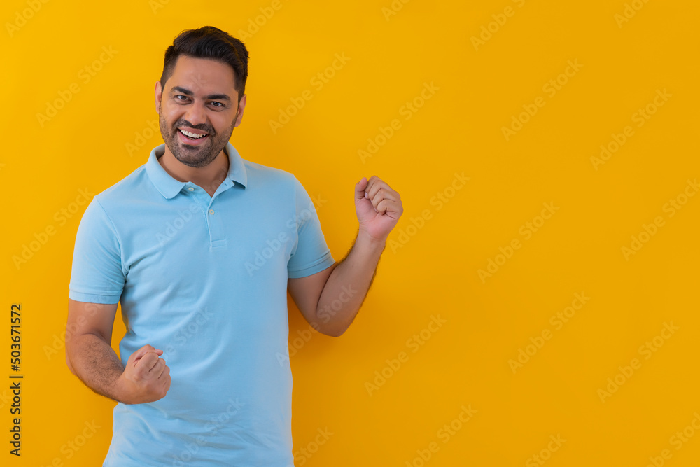 Portrait of happy young man cheering with raising his fists Portrait of happy young man cheering with raising his fists