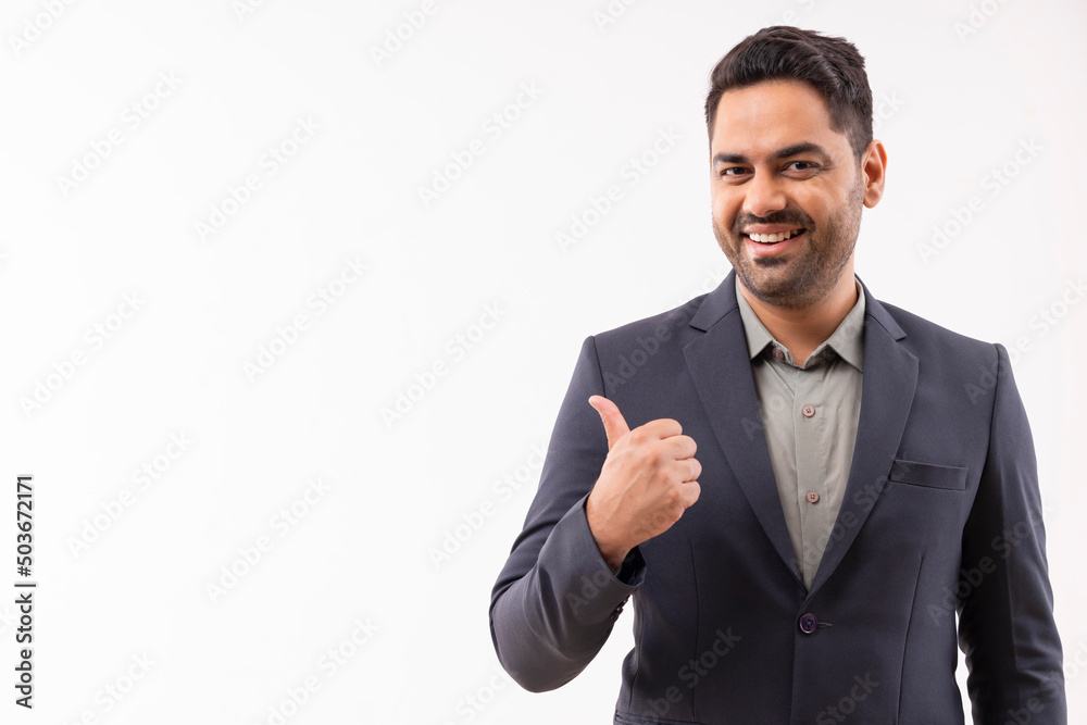 Portrait of a cheerful young businessman in formal outfit pointing sideways Portrait of a cheerful young businessman in formal outfit pointing sideways