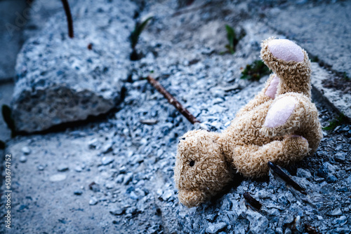 Conceptual image  Russia s war against Ukraine. A pile of construction debris and children s toy teddy bear. Copy space.