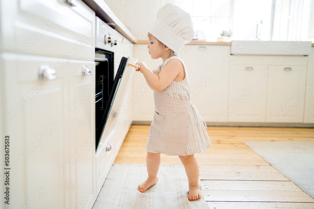 A little girl is playing in the kitchen, a chef's uniform. A little girl is playing in the kitchen, a chef's uniform.
