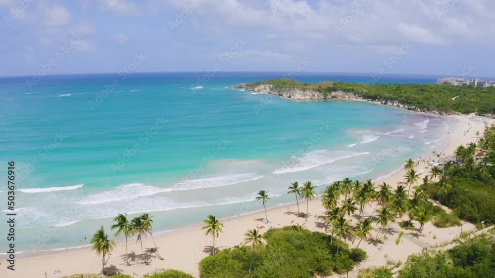 Sea coast with palm trees. Green palm trees on the white sand of a wild beach. Summer sunny day on a tropical peninsula. Turquoise Caribbean Sea under a blue cloudy sky. Travel to tropical paradise. Sea coast with palm trees. Green palm trees on the white sand of a wild beach. Summer sunny day on a tropical peninsula. Turquoise Caribbean Sea under a blue cloudy sky. Travel to tropical paradise.