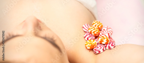 Waxing, depilation armpit concept. Colored round candies lying down on the female armpit, close up