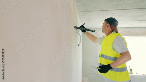 Wallpaper Mural Repair work in the room. Plasterer painter construction worker plasters the wall with a plaster spatula. Plastering and leveling of unevenness on a wall by means of finishing plaster. Torontodigital.ca