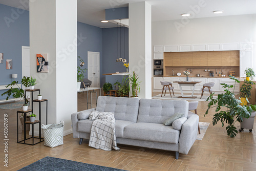 minimalist modern interior design huge bright apartment with an open plan in Scandinavian style in white  blue and dark blue colors with columns in the center. includes kitchen area  office and lounge