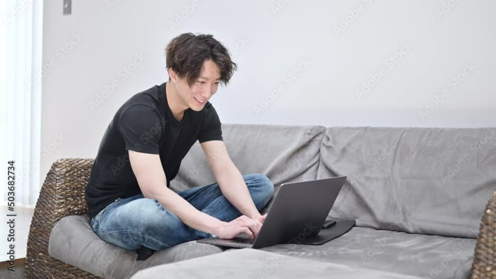 チャットをしながらパソコンの仕事をするハンサムな男性 チャットをしながらパソコンの仕事をするハンサムな男性