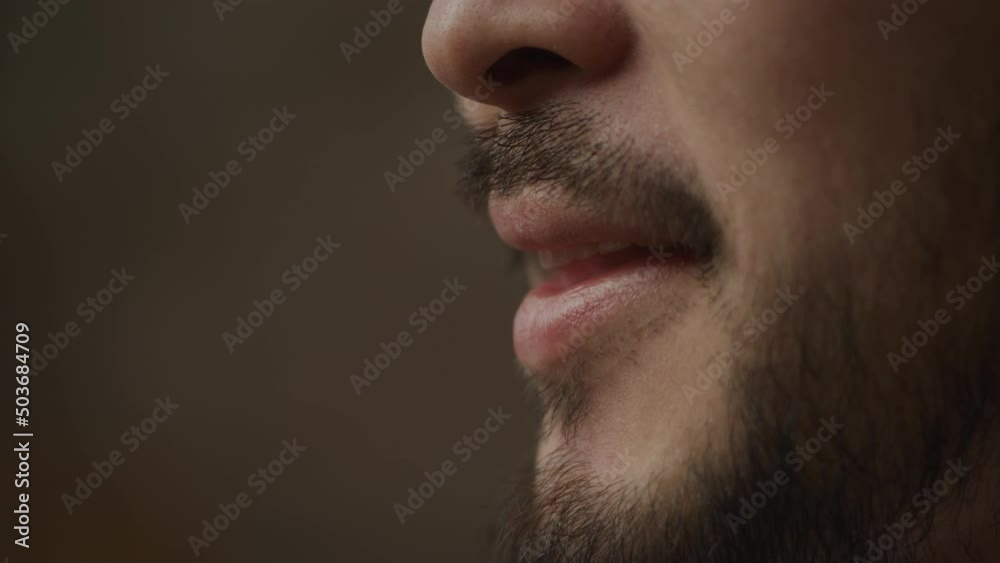 Extreme close up of an asian man's mouth talking and smiling in slow motion indoors Extreme close up of an asian man's mouth talking and smiling in slow motion indoors