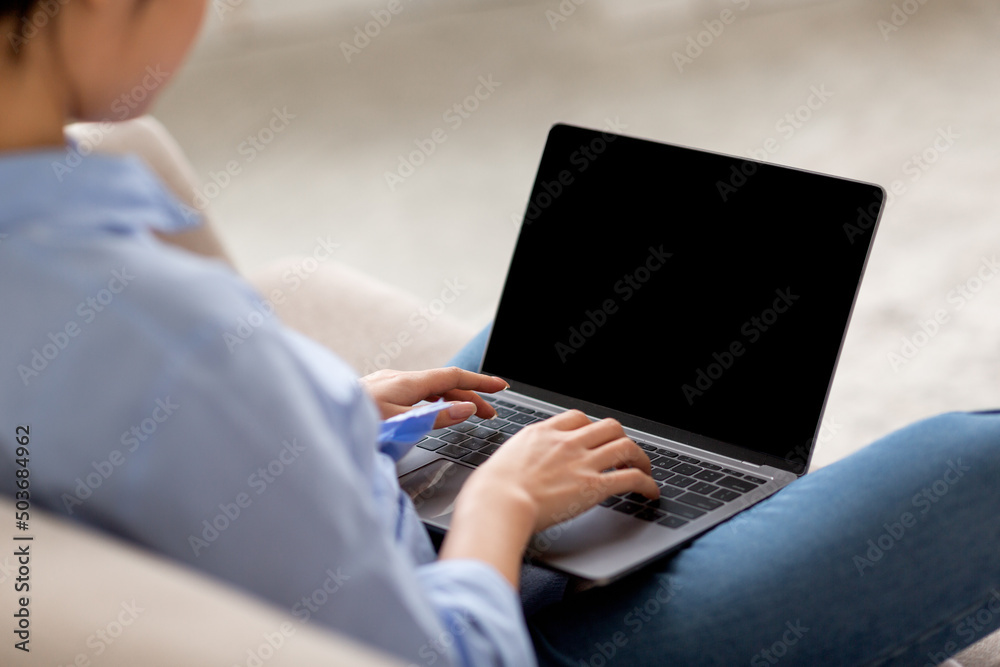 Fototapeta premium Over shoulder shot of woman using laptop, mockup