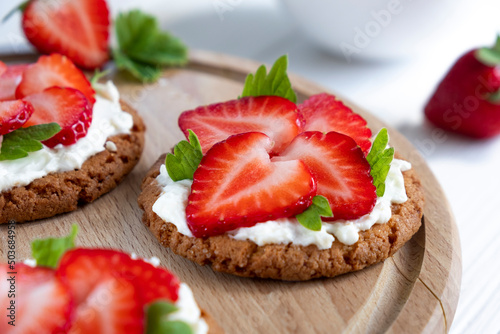 Homemade strawberry tart with oat biscuit and whipped cream. Recipe of simple berry cake for breakfast or holiday. Summer light dessert.