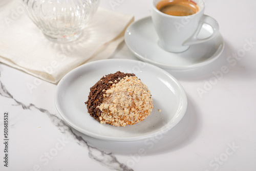 Fresh dessert on a white plate among white dishes with tea and coffee in a cafe