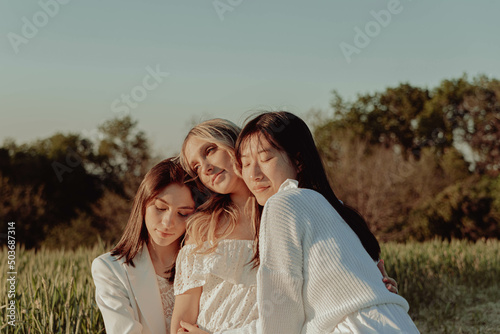 Embrace of three girls in countryside.