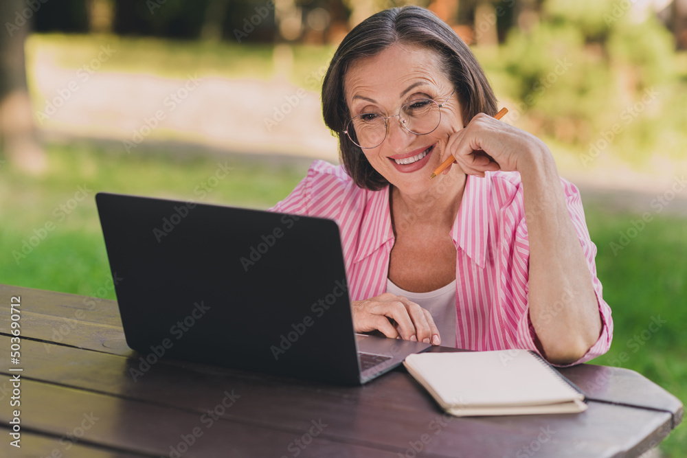 Portrait of positive aged person use wireless netbook read message email fresh air outdoors Portrait of positive aged person use wireless netbook read message email fresh air outdoors