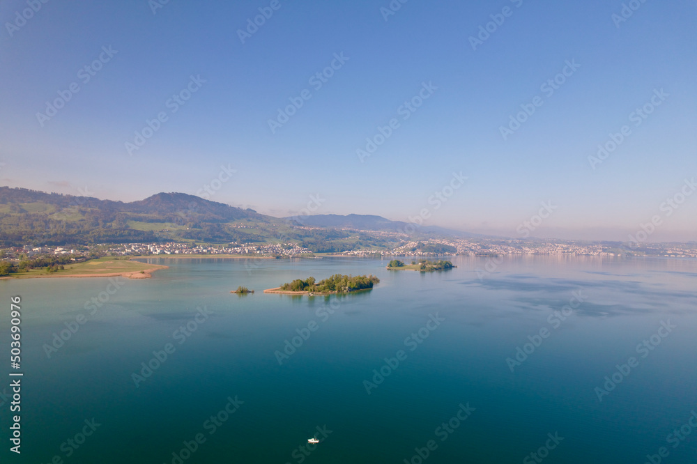 Aerial view from City of Rapperswil-Jona with Lake Zürich and two islands on a sunny spring day. Photo taken April 28th, 2022, Raperswil-Jona, Canton St. Gallen, Switzerland.