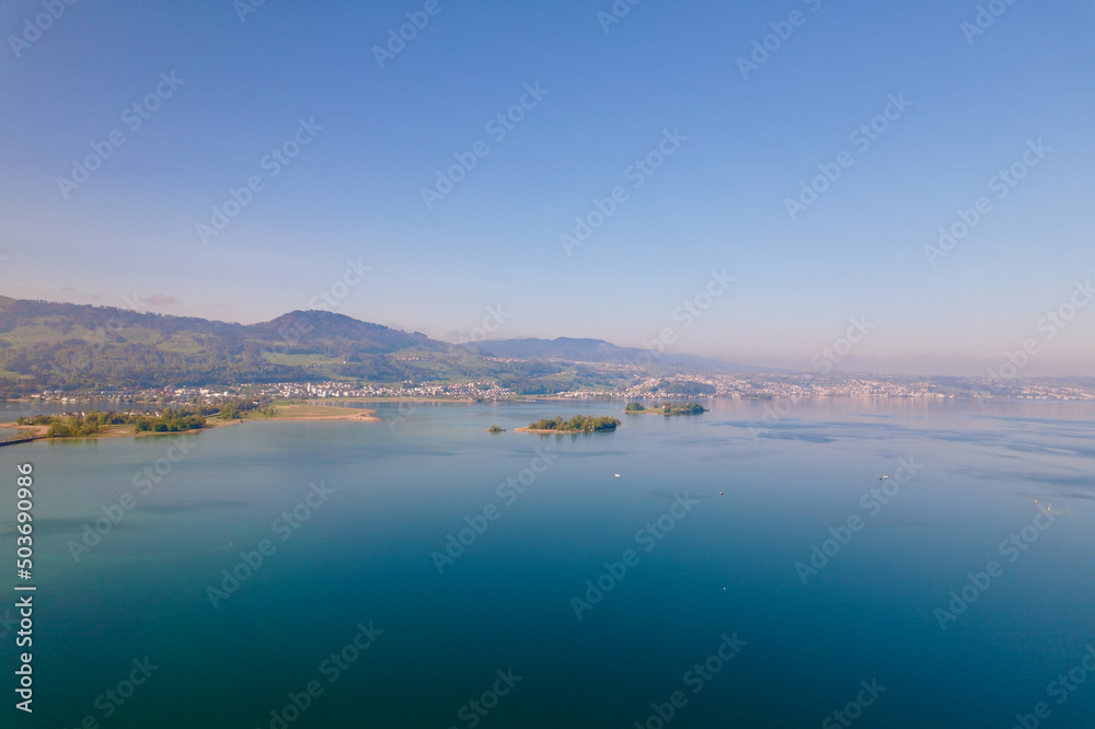 Aerial view from City of Rapperswil-Jona with Lake Zürich and two islands on a sunny spring day. Photo taken April 28th, 2022, Raperswil-Jona, Canton St. Gallen, Switzerland.