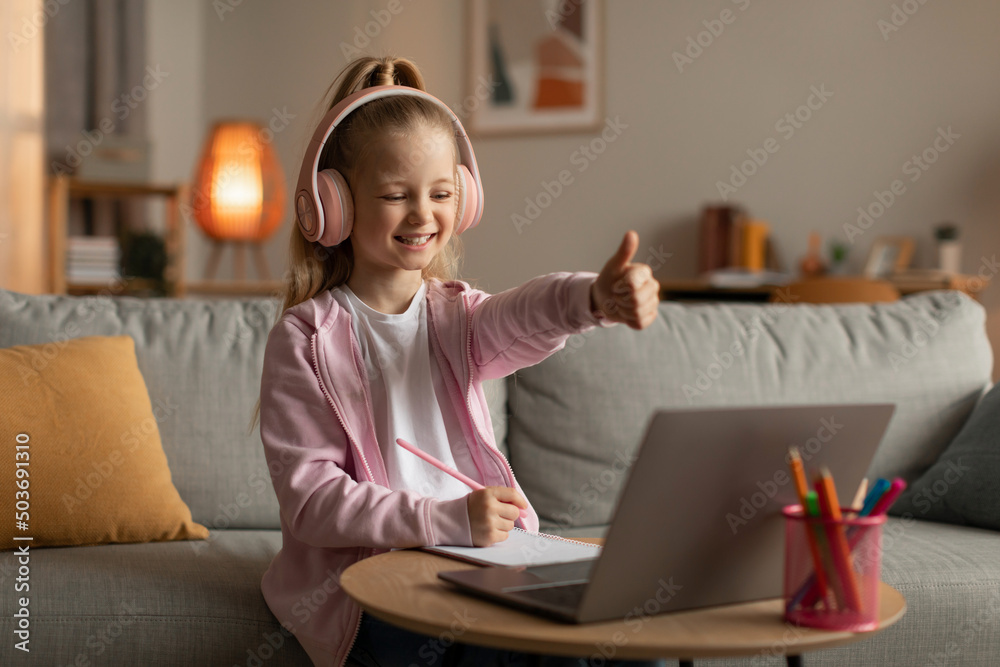 Little Girl Gesturing Like To Laptop Approving E-Learning At Home Little Girl Gesturing Like To Laptop Approving E-Learning At Home