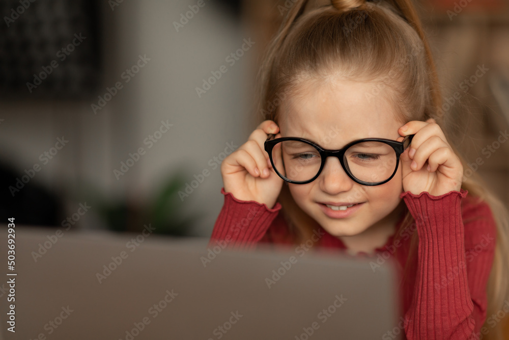Little Girl Squinting Eyes Using Laptop Wearing Glasses At Home Little Girl Squinting Eyes Using Laptop Wearing Glasses At Home