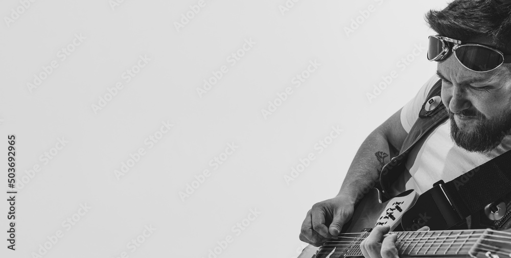 Solo performance Black and white portrait of stylish rock musician with electric guitar isolated on white background. Concept of art, music, style Solo performance Black and white portrait of stylish rock musician with electric guitar isolated on white background. Concept of art, music, style