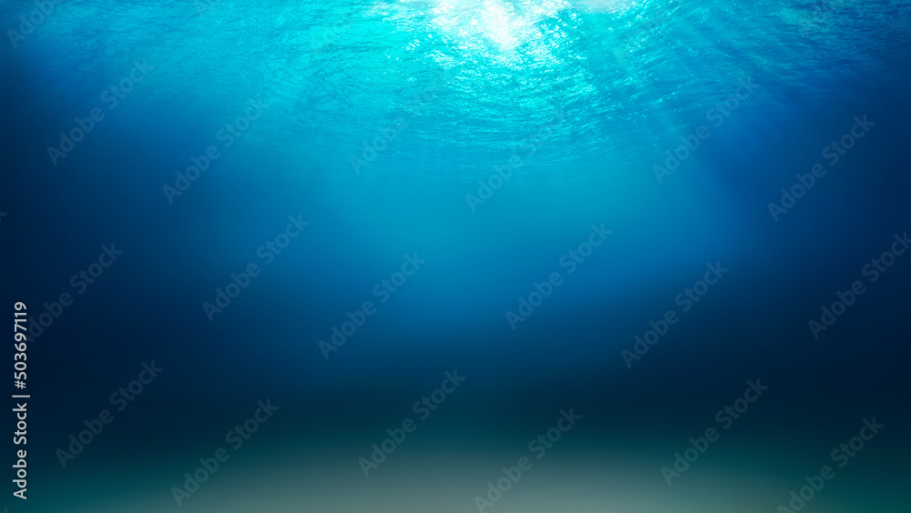 Sunlight shining through the surface of the blue ocean, sea, with dark waters and sandy seabed below.