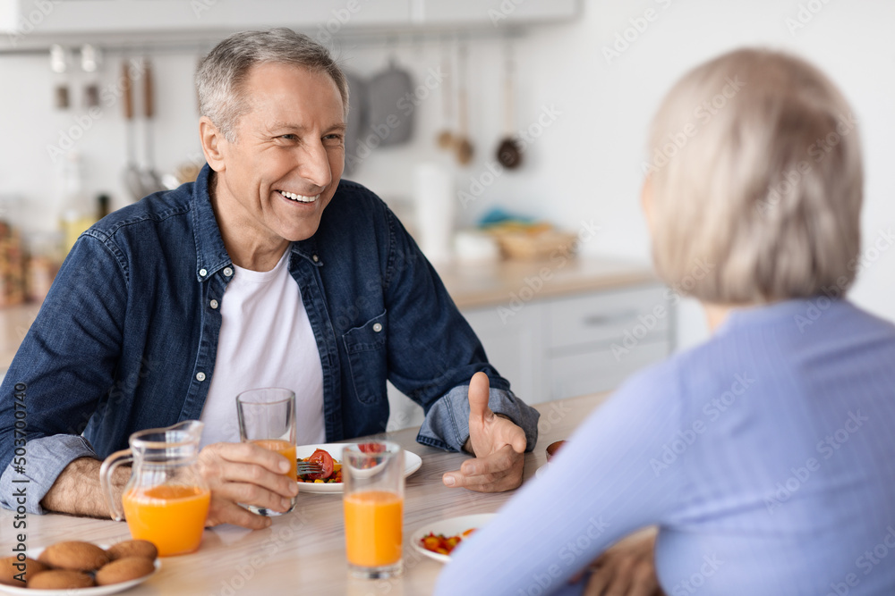 Cheerful senior man having breakfast with his wife Cheerful senior man having breakfast with his wife