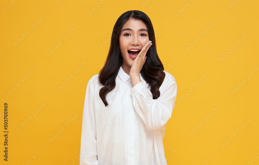Amazed young Asian teen woman looking at camera on yellow background. Amazed young Asian teen woman looking at camera on yellow background.