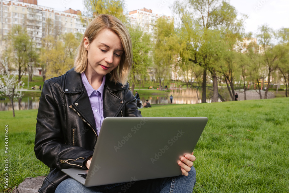 Girl working on a computer in the park. Remote work freelancer Girl working on a computer in the park. Remote work freelancer