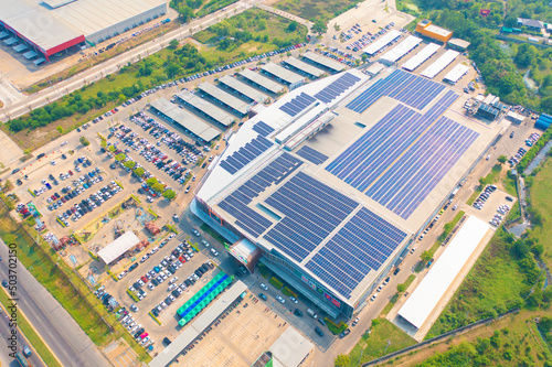 Aerial view of solar panels or solar cells on the roof of shopping mall building rooftop. Power plant, renewable clean energy source. Eco technology for electric power in industry.