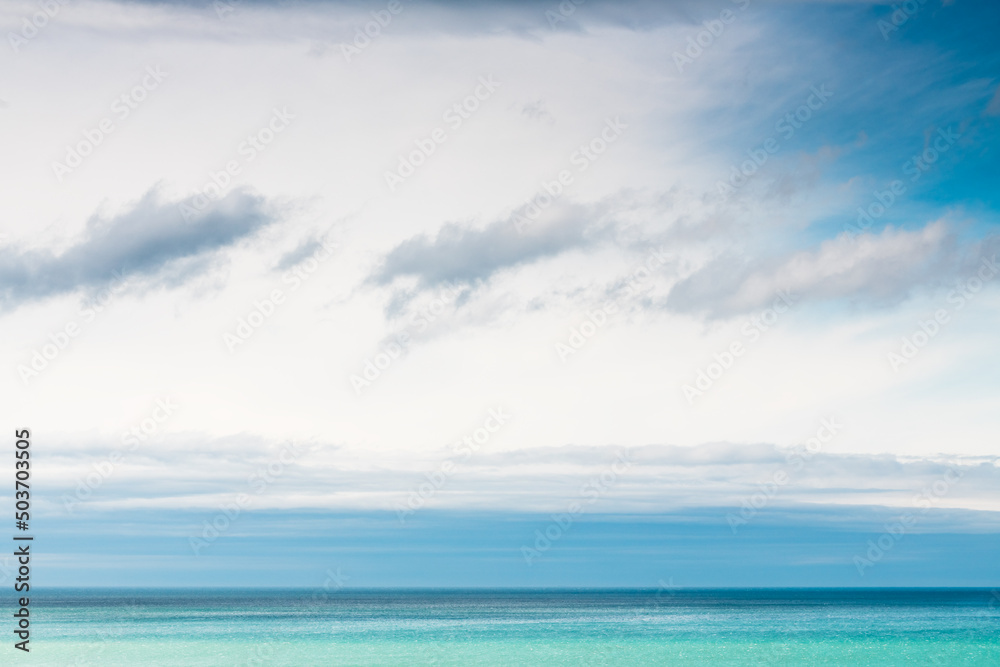 Sky with white and blue clouds over the blue sea. Abstract summer nature background.