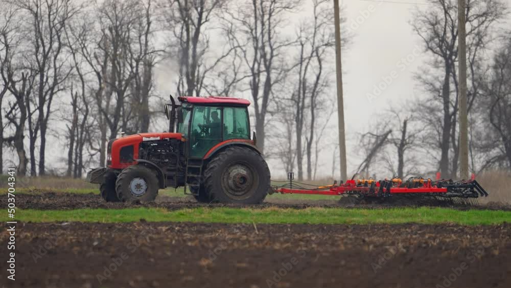 Tractor with harrow system plowing ground on cultivated farm field, pillar of dust trails behind, preparing soil for planting new crop, agriculture concept. Tractor with harrow system plowing ground on cultivated farm field, pillar of dust trails behind, preparing soil for planting new crop, agriculture concept.