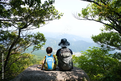 山頂で休憩する親子