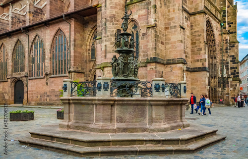 Lovely view of the famous Late Renaissance bronze Fountain of Virtues at the west facade of the church St. Lorenz in Nuremberg  Germany. The seven figures represent the 7 virtues of the Middle Ages.