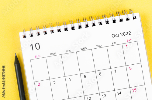 October 2022 desk calendar on yellow background.