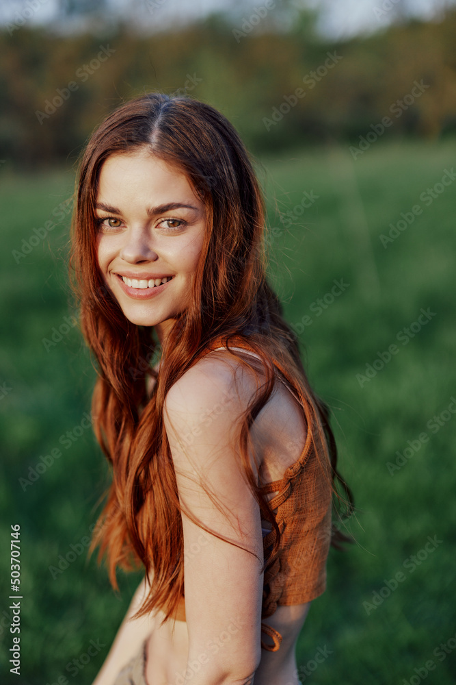A beautiful redheaded woman laughs and smiles with her teeth in the bright sunset sunlight. The concept of healthy living and good nutrition A beautiful redheaded woman laughs and smiles with her teeth in the bright sunset sunlight. The concept of healthy living and good nutrition