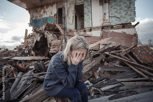 Photography young girl screams against the background of a destroyed house