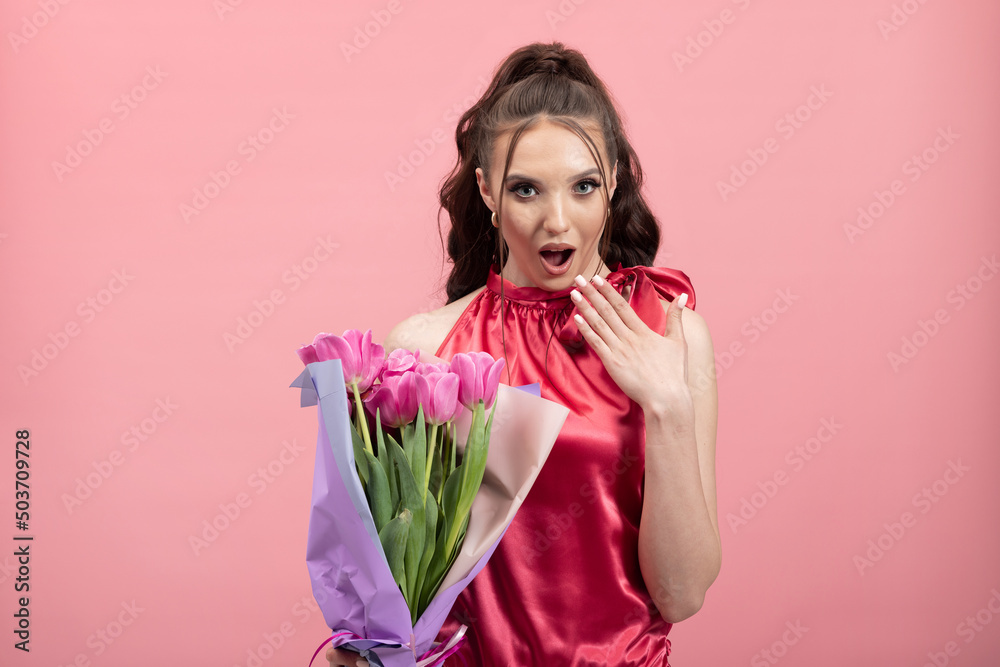 Surprised, happy young woman shocked to receive flowers from a stranger, received a package, holding beautiful gerberas, amazed to see a boy standing with a natural gift. Unexpected gift. Surprised, happy young woman shocked to receive flowers from a stranger, received a package, holding beautiful gerberas, amazed to see a boy standing with a natural gift. Unexpected gift.