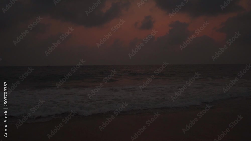 Wide angle slow motion shot of Calangute beach during the sunset with clouds above the ocean at North Goa in Goa, India. Clouds above the sea waves with dramatic sky after the sunset. Beach Background Wide angle slow motion shot of Calangute beach during the sunset with clouds above the ocean at North Goa in Goa, India. Clouds above the sea waves with dramatic sky after the sunset. Beach Background