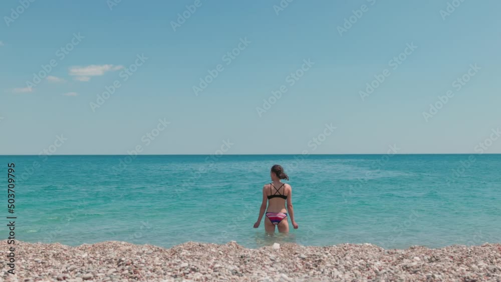Girl in a swimsuit on the beach, a woman on a summer vacation on the sea coast Girl in a swimsuit on the beach, a woman on a summer vacation on the sea coast