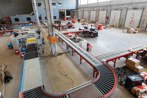 High angle view of empty conveyor belt with cardboard boxes and furniture in distribution warehouse photo