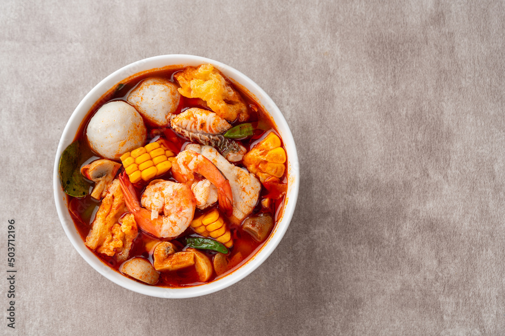 Fototapeta premium Shrimp soup bowl, Tom yum or tom yam is a type of hot and sour Thai soup, usually cooked with shrimp (prawn). Tom yum has its origin in Thailand.