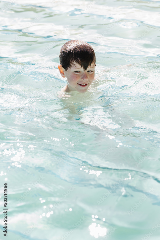 Adorable child swimming in pool on sunny day Adorable child swimming in pool on sunny day